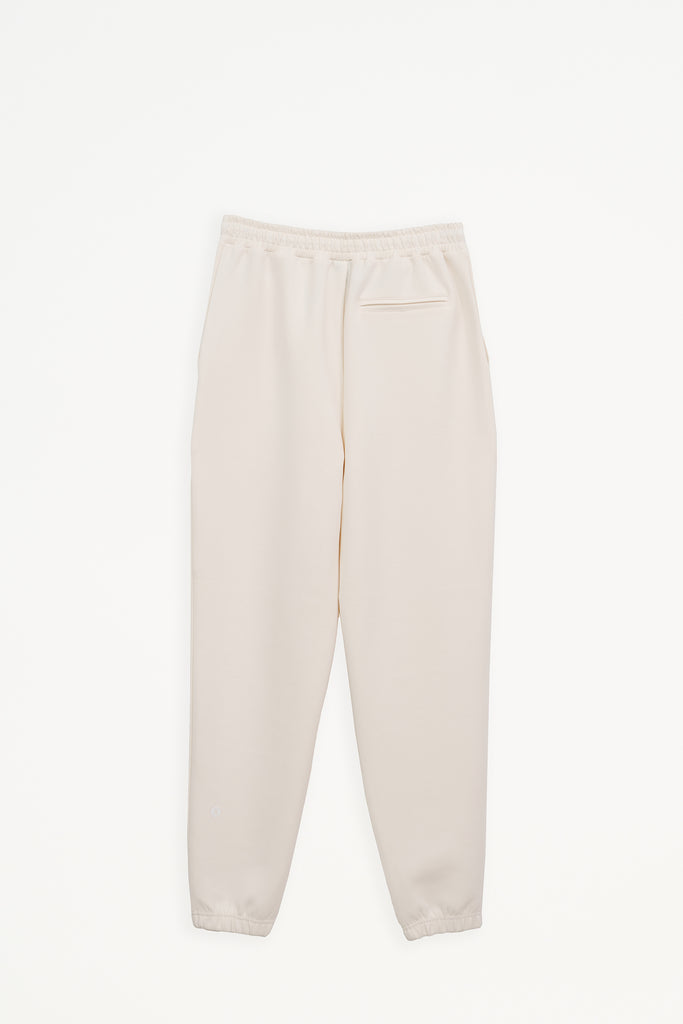 Pantalón jogger confeccionado en tejido interlock de mujer Tantä. Color blanco roto